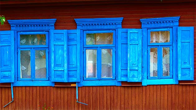 Kolorowe okiennice białoruskiego domu. Dom, jak większość na Białorusi, jest drewniany, więc zimą nieco chłodno. Fot. W.Ganczarek