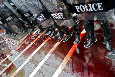 Oddział policji stoi w kałuży krwi wylanej przez Czerwone Koszule na ulicy Bangkoku. Wtedy jeszcze krew polała się zgodnie z planem: została zebrana od ochotników i wylana m.in. przed parlamentem. W ostatnią sobotę to się zmieniło (Zdjęcie: vancouversun.com)